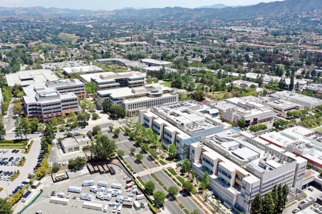 An aerial photo shows a large company headquarters with various buildings.